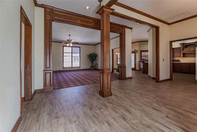 interior space with ornate columns, ornamental molding, hardwood / wood-style flooring, and ceiling fan