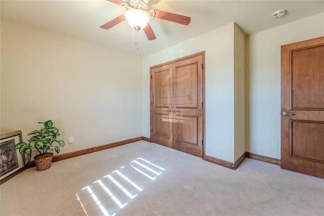 unfurnished bedroom featuring ceiling fan and light colored carpet