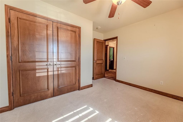 unfurnished bedroom with ceiling fan and light colored carpet