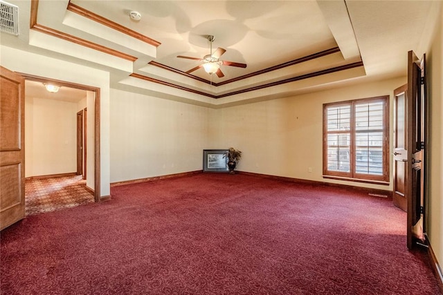 carpeted empty room with crown molding, ceiling fan, and a raised ceiling