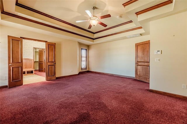 carpeted empty room with crown molding, ceiling fan, and a raised ceiling