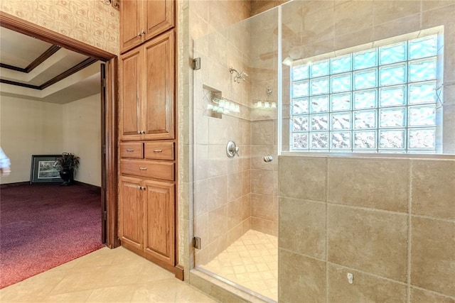 bathroom with ornamental molding, a tray ceiling, tile patterned floors, and walk in shower