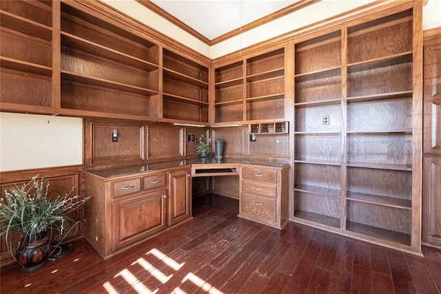 unfurnished office featuring crown molding, dark hardwood / wood-style floors, and built in desk