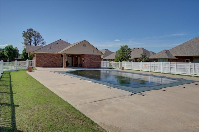view of pool featuring a lawn, a patio area, fence, and a fenced in pool