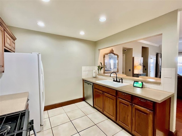 kitchen with dishwasher, white refrigerator, sink, light tile patterned floors, and tasteful backsplash