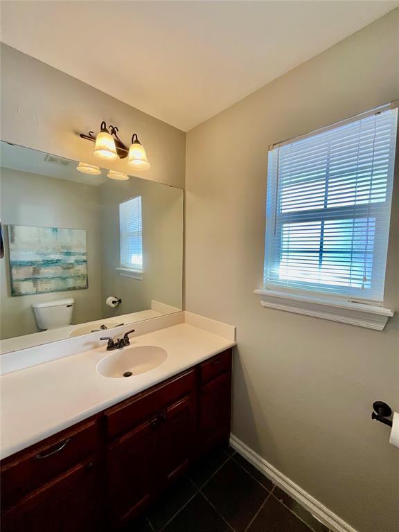 bathroom with tile patterned flooring, vanity, and toilet