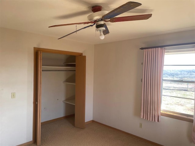 unfurnished bedroom with ceiling fan, light carpet, and a closet