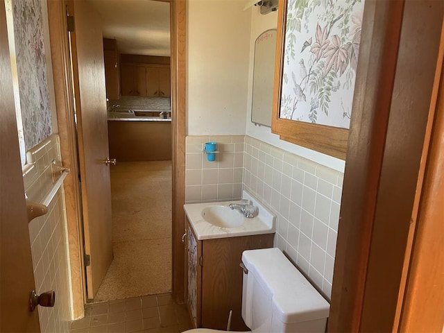 bathroom with tile patterned floors, vanity, toilet, and tile walls