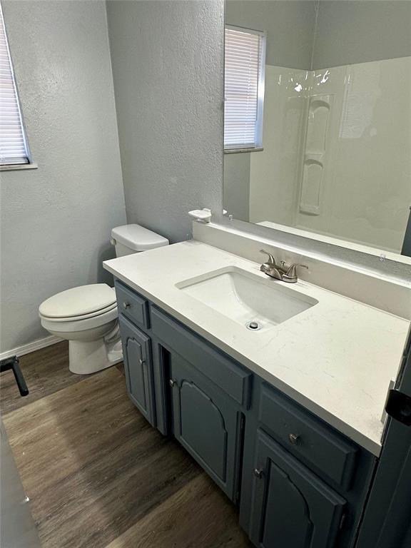 bathroom with hardwood / wood-style flooring, toilet, and vanity