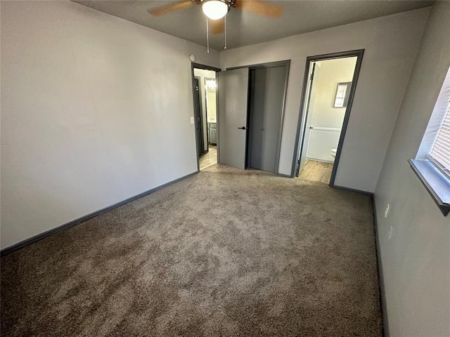 unfurnished bedroom with ceiling fan, ensuite bath, and light carpet