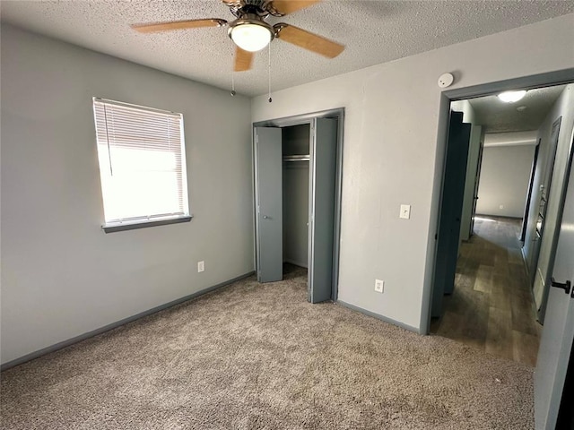 unfurnished bedroom featuring carpet, a textured ceiling, a closet, and ceiling fan