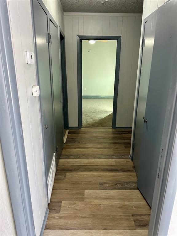 hallway featuring a textured ceiling and hardwood / wood-style floors