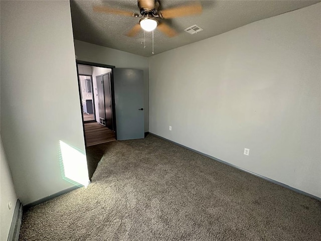 unfurnished bedroom with ceiling fan, dark colored carpet, and a textured ceiling