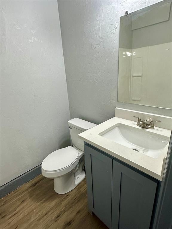 bathroom featuring hardwood / wood-style flooring, toilet, and vanity