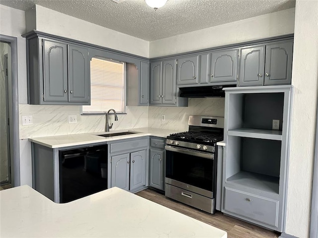 kitchen with dishwasher, stainless steel gas range, gray cabinetry, sink, and dark hardwood / wood-style floors