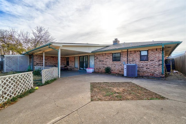 rear view of house featuring central AC and a carport