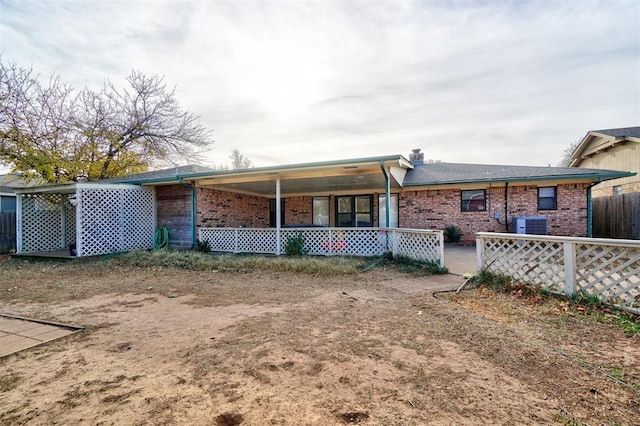 back of house with central AC unit