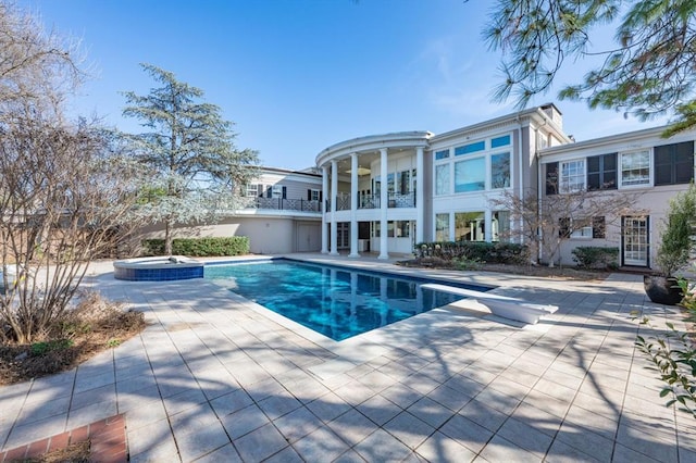 view of swimming pool featuring an in ground hot tub, a diving board, and a patio area