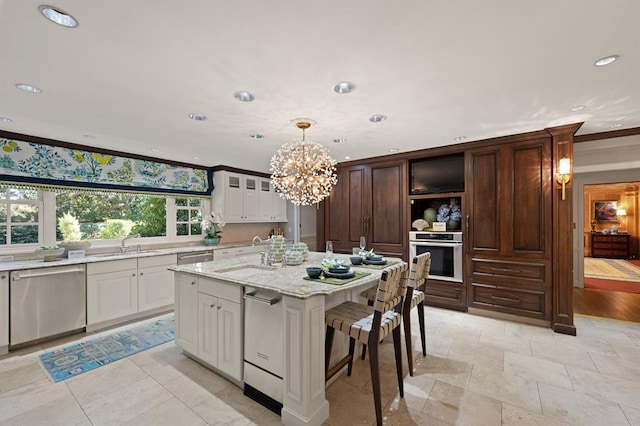 kitchen with sink, decorative light fixtures, ornamental molding, a center island with sink, and appliances with stainless steel finishes