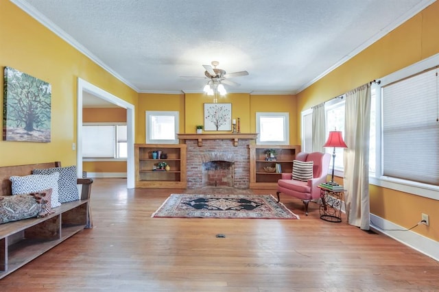 living room with hardwood / wood-style flooring, a brick fireplace, and ornamental molding