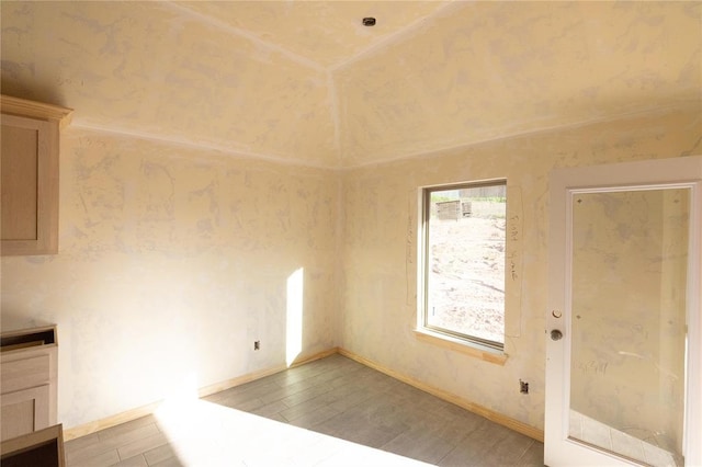 unfurnished dining area with wood finished floors and baseboards