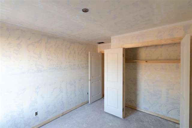 unfurnished bedroom with a closet and concrete flooring