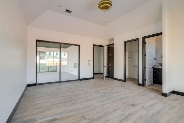 unfurnished bedroom featuring access to outside, connected bathroom, and a tray ceiling