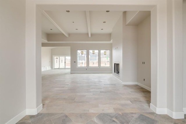 unfurnished living room featuring beam ceiling