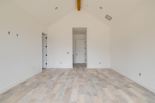 spare room with light wood-type flooring, beam ceiling, and high vaulted ceiling