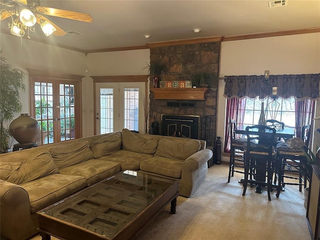 living room with crown molding, a fireplace, and a wealth of natural light