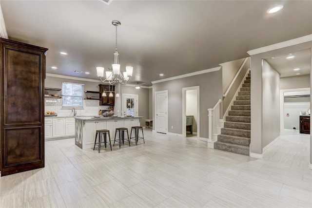 kitchen featuring dark brown cabinetry, a kitchen island, tasteful backsplash, a breakfast bar area, and white cabinets