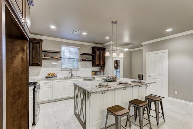 kitchen featuring light stone countertops, sink, a center island, white cabinets, and appliances with stainless steel finishes