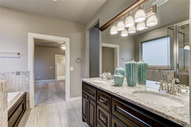 bathroom with vanity, ceiling fan, and a tub