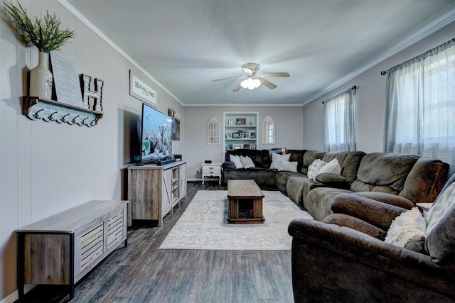 living room featuring ceiling fan, built in features, dark hardwood / wood-style floors, and crown molding