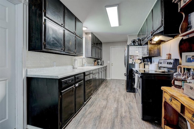 kitchen featuring black appliances, sink, tasteful backsplash, and light hardwood / wood-style flooring