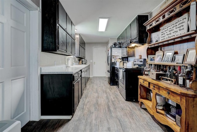 kitchen featuring light hardwood / wood-style floors, electric stove, black fridge, and sink