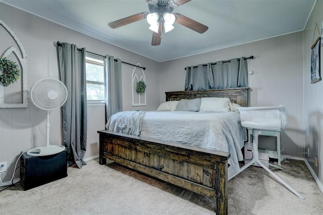 bedroom featuring ceiling fan, wooden walls, and carpet flooring