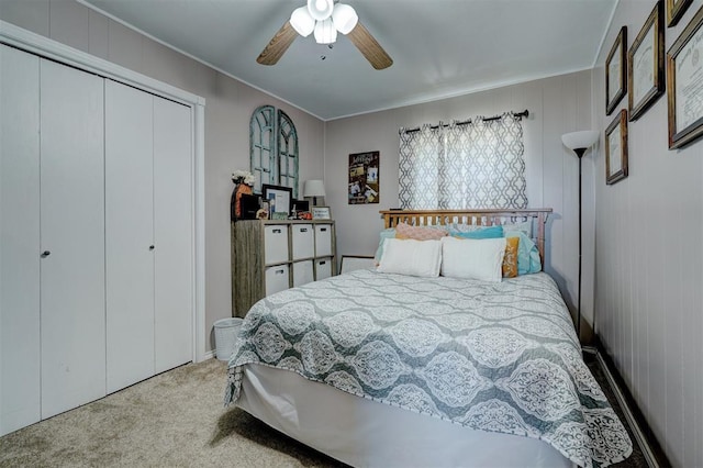 carpeted bedroom featuring ceiling fan, a closet, and wooden walls