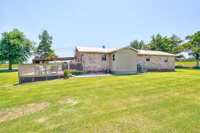 back of house featuring central air condition unit, a deck, and a yard