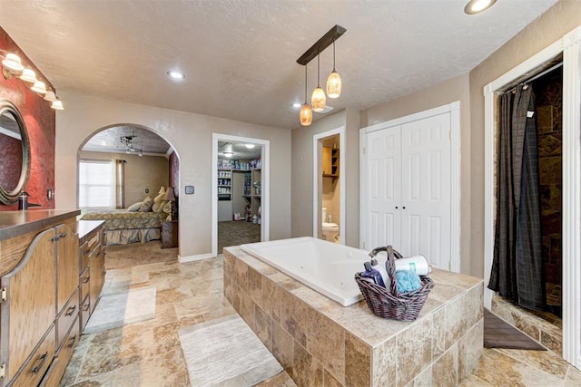 bathroom with shower with separate bathtub, a textured ceiling, and toilet