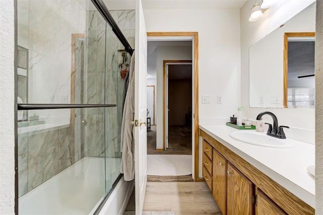 bathroom featuring vanity, hardwood / wood-style flooring, and combined bath / shower with glass door