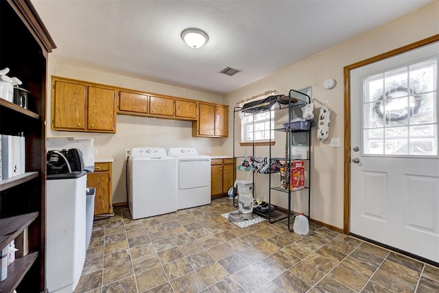 clothes washing area featuring cabinets and washer and dryer