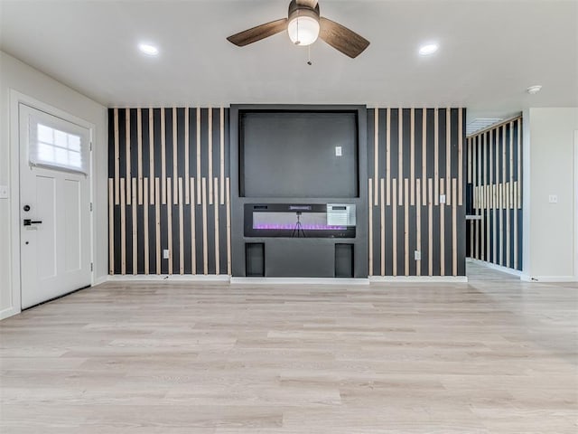 unfurnished living room featuring ceiling fan and light wood-type flooring