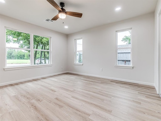 spare room with ceiling fan, light hardwood / wood-style floors, and a wealth of natural light