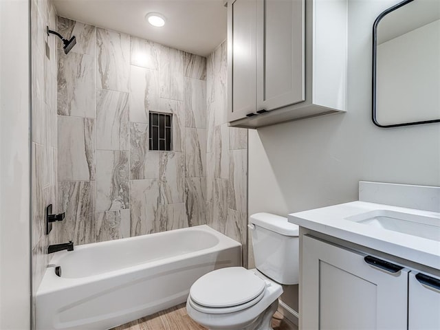 full bathroom with vanity, tiled shower / bath combo, and toilet