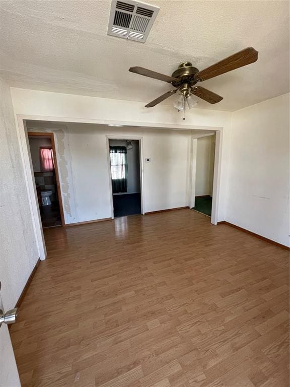 unfurnished room featuring hardwood / wood-style floors, ceiling fan, and a textured ceiling