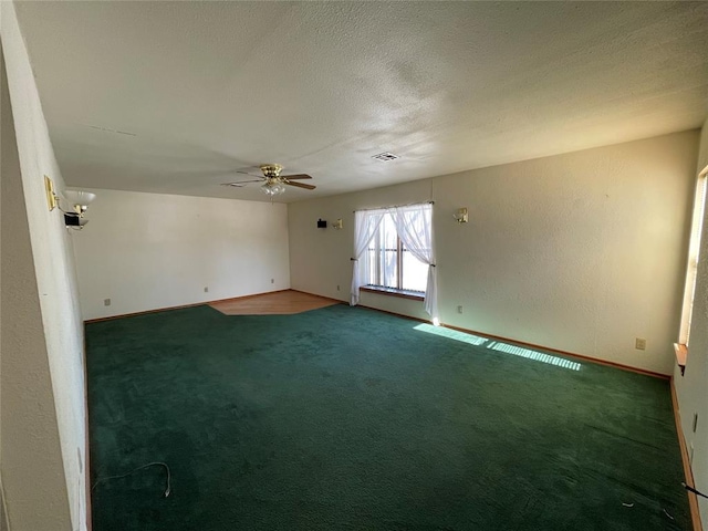 carpeted spare room with ceiling fan and a textured ceiling