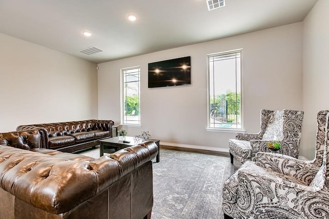 living room featuring baseboards, visible vents, wood finished floors, and recessed lighting