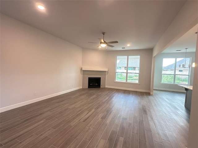 unfurnished living room featuring dark hardwood / wood-style flooring and ceiling fan