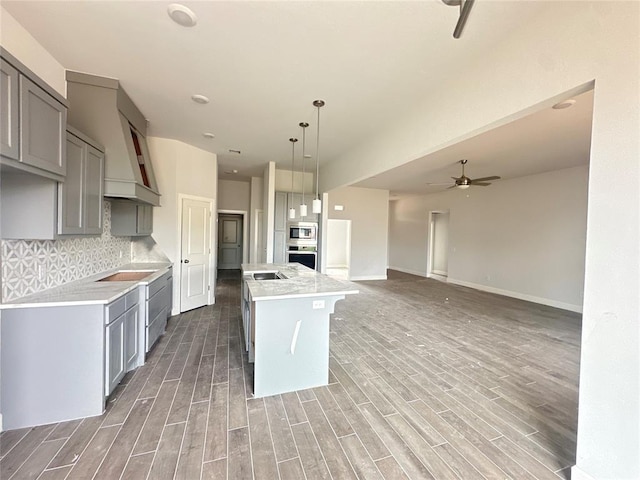 kitchen featuring tasteful backsplash, stainless steel appliances, ceiling fan, pendant lighting, and a center island